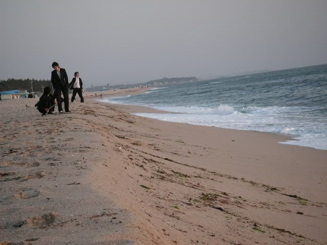 korean dudes in suits, at 5 am, on the beach with beers